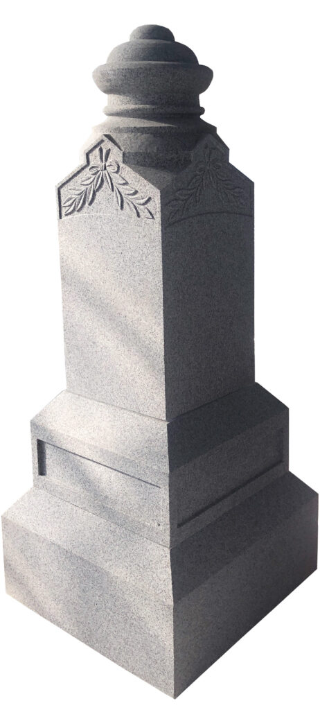 Dome Top Obelisk Granite gravestone with a rounded top, featuring subtle floral carvings, set against a backdrop of lush greenery. Represents remembrance and honor.