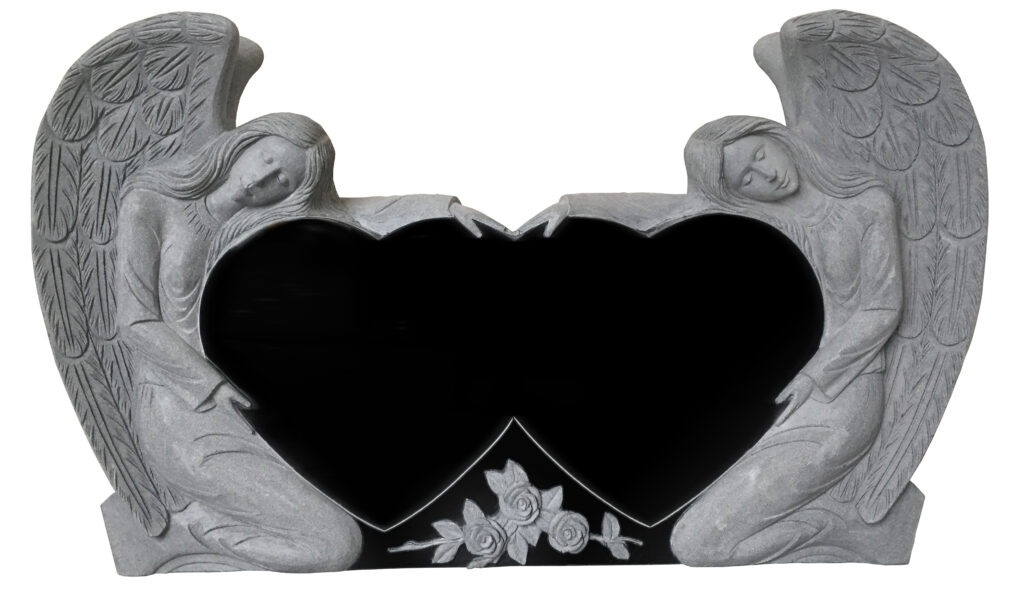 Two gray stone angels embrace a heart-shaped black void, featuring rose carvings below. The sculpture symbolizes love and remembrance.