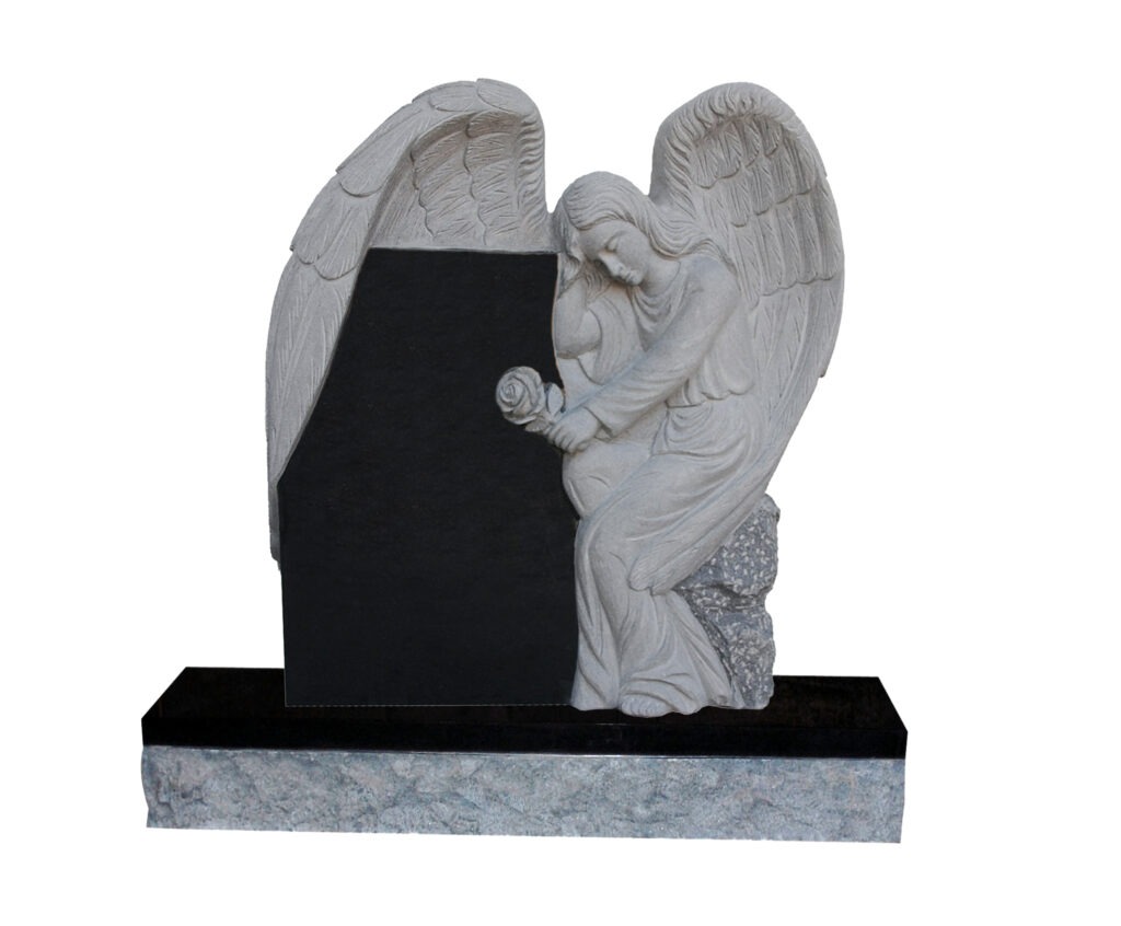 Granite gravestone featuring a sitting angel holding a rose, set against a black slab, in a serene green cemetery setting.